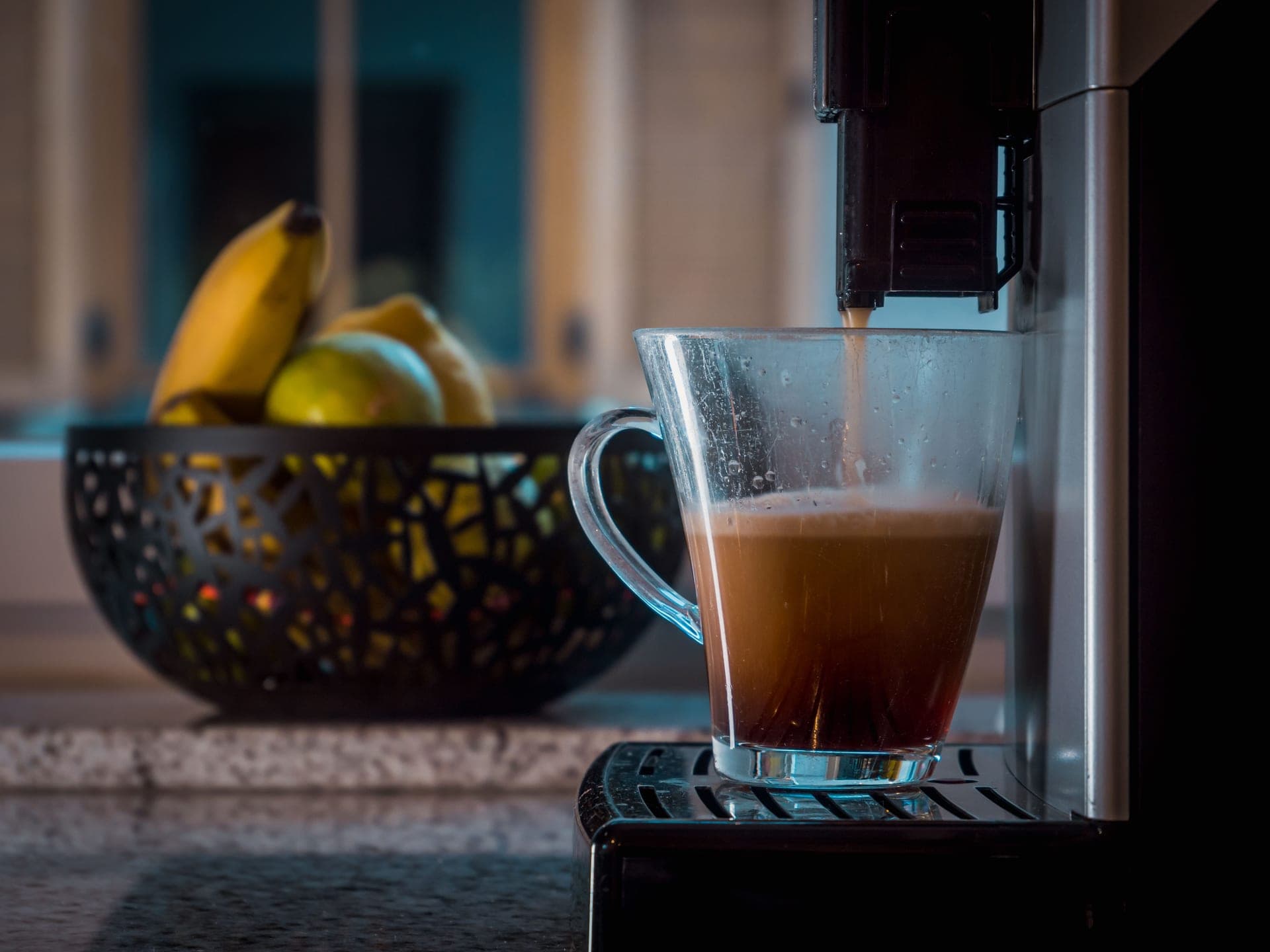 An espresso machine pouring a shot on a home kitchen counter