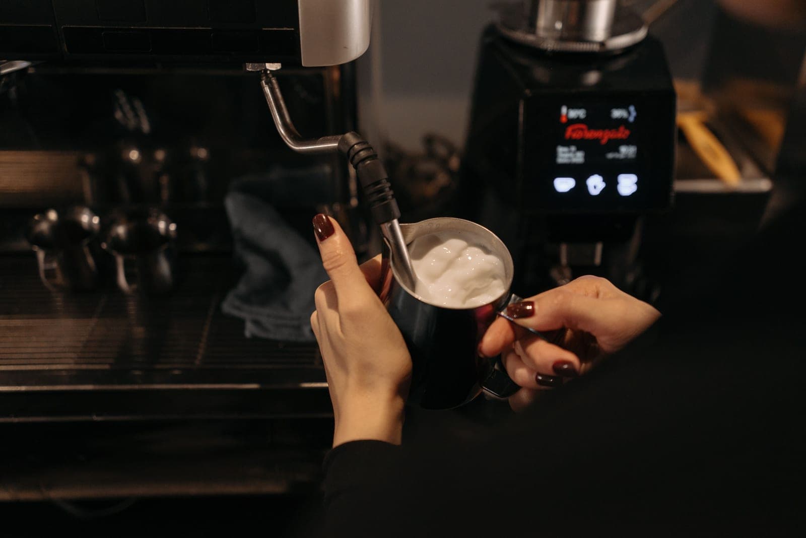 Milk being steamed in a stainless pitcher